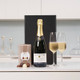 Personalised Champagne & Chocolates: A bottle of champagne sits on a white countertop with two fluted glasses filled partially. Next to the champagne is a Butler's box of chocolates, and a sleek black box is visible in the background. Personalised Champagne & Chocolates: A bottle of champagne sits on a white countertop with two fluted glasses filled partially. Next to the champagne is a Butler's box of chocolates, and a sleek black box is visible in the background.